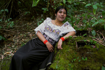 Indigenous woman wearing traditional clothes resting in lush forest