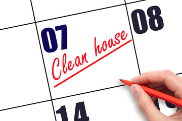 7th day of the month.  Hand writing Clean house reminder and drawing a line on calendar with red...
