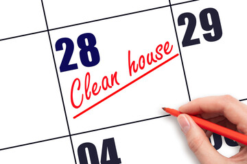 28th day of the month.  Hand writing Clean house reminder and drawing a line on calendar with red...