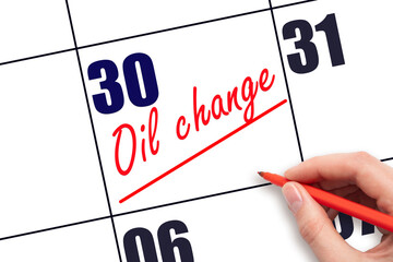 30th day of the month.  Hand writing Oil change reminder and drawing a line on calendar with red...