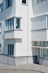 Modern building facade with windows and minimalist design, showcasing clean lines and bright white exterior.