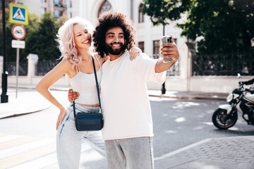 Smiling beautiful woman and her handsome boyfriend. Woman in casual summer clothes. Happy cheerful...