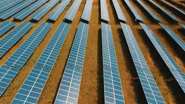 Solar panels photovoltaics in solar farm. Aerial video footage, view of solar panels at a renewable energy energy of the future generation farm at Sunset in Lincolnshire, UK