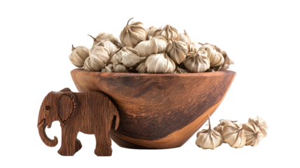Rustic bowl overflowing with cardamom pods and a wooden elephant isolated on transparent background