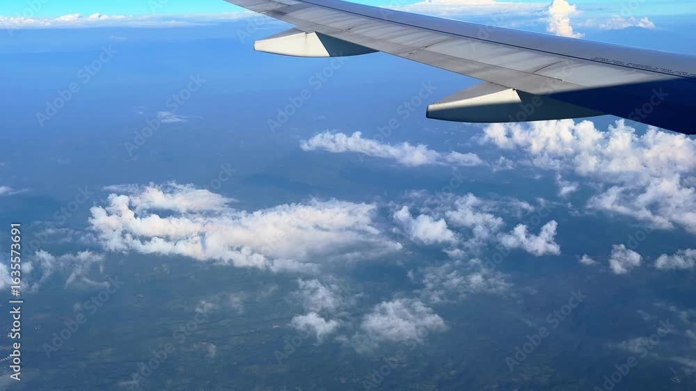 Aufkleber soaring view from airplane window showing the wing and scattered clouds over vast terrain—ideal for 