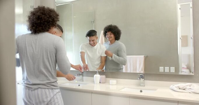 Father and son entering bathroom picking toothbrushes applying toothpaste brushing teeth rinsing