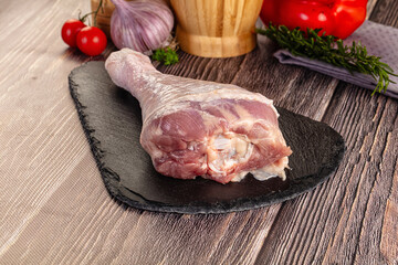 Raw turkey drumstick leg over board
