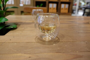 A glass of wine is sitting on a wooden table