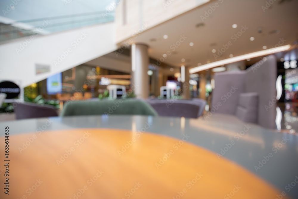 Poster a blurry view of a table in the center of a shopping mall. the background is filled with bokeh and h