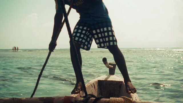 African fisherman poling boat on ocean . Traditional sailing
