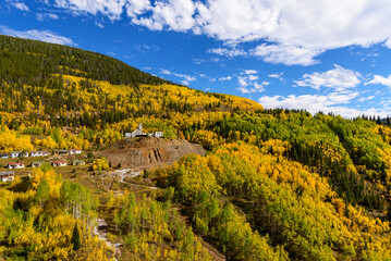 The blue sky above and golden aspens below soften the sharp edges of this abandoned place. Gilman Colorado