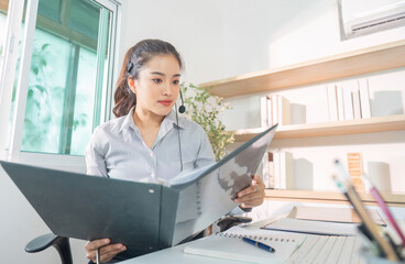 Remote Work. Focused woman in headset analyzing documents in home office.