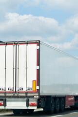 Obraz premium White shipping truck driving across forest road