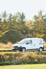 Fototapeta premium Commercial van moving on rural paved road