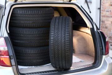 New summer tires stacked inside car trunk