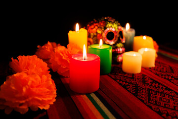 Black painted skull with magnolia flowers and candles as part of a Day of the Dead altar