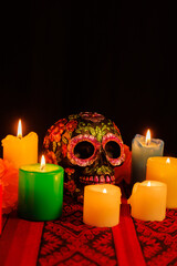 Colorful altar arrangement for Día de Muertos with a black skull and festive flowers