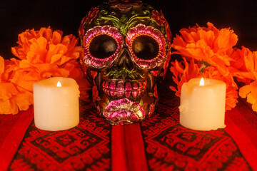 Honoring the dead with black skull, flowers, candles, and magnolias on a vibrant Mexican altar