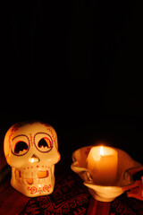Peaceful Day of the Dead altar with white ceramic skull, magnolias, white candles and colorful...