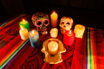 Día de los Muertos altar with ceramic skulls, metallic flowers and vibrant candlelight on...