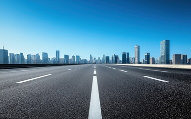 Obraz premium A minimalist wide-angle view of a clean empty highway with white lines leading to a modern city skyline under clear blue sky, showcasing urban architecture and conveying calm driving tranquility