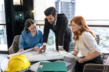 Male Indian real estate project manager working and brainstorming with female architect teammates 