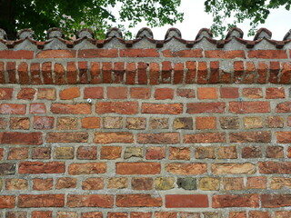 Old brick wall with monk and nun tiles as coping. Historic, weatherproof and structured. Copyspace