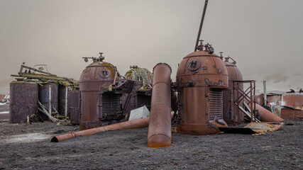 Remains of rusting whaling station in Deception Island Antarctica on the background of cloudy sky © IrenaB