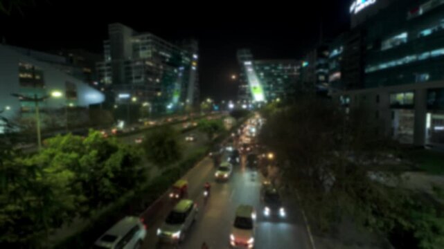 Blurred top angle view of a busy evening road traffic in Cyber City, Haryana, India. Time lapse motion video for background.	