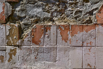 Old crumbling wall with red tiles.Abandoned space