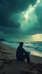 Obraz premium A lone figure sits on a desolate beach, silhouetted against a stormy sky, conveying a profound sense of isolation and emotional distance from the world , sky, melancholy, grey