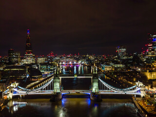 London night cityscape with tower bridge. Famous landmark illumination and shard skyscraper light reflection on river thames water surface