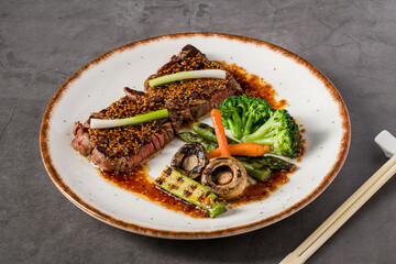 Sliced spicy beef served with grilled vegetables and spicy sauce