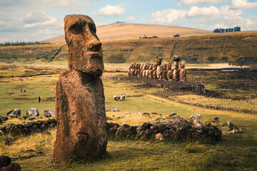 The Traveler Moai at the Tongariki Archaeological Site on Rapa Nui (Easter Island), Chile. In the background, Ahu Tongariki with 15 moai statues and the top of the Poike Volcano.