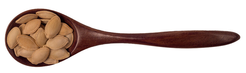 Pumpkin seeds in a wooden spoon isolated on white, top view