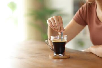 Woman hand stirring coffee with infinite copy space