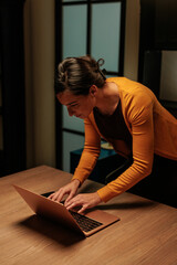 Office worker standing while finishing her work in the nightshift