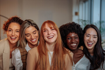 Five smiling businesswomen in their office