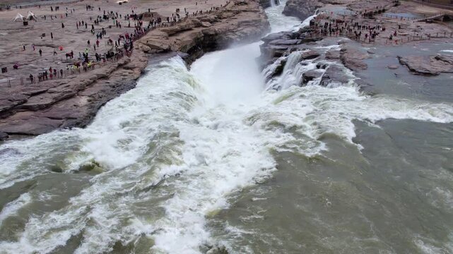 Drone view of Hukou Waterfall in Shanxi Province, China, it is a magnificent sight of the surging Yellow River water, filled with energy and awe inspiring，4k slow motion footage aerial view.