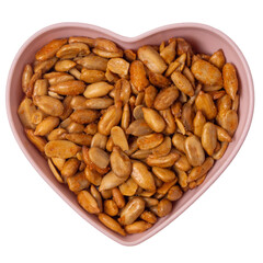 Peeled sunflower seeds in teriyaki sauce in a heart-shaped plate isolated on white background, top view