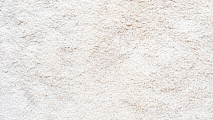 Close up of a textured white surface a soft fluffy carpet or rug. The detailed irregular pattern creates a clean and versatile background for various design projects.