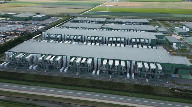 Drone panorama of a large data center facility in Eemshaven, Netherlands, showing high-tech infrastructure, cooling systems, and sustainable tech hub architecture.