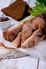 Pieces of hot smoked catfish clarias on parchment paper. Close-up