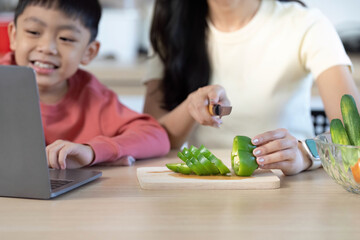 Family Cooking Fun: Mother and Child Chopping Fresh Green Peppers
