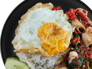Stir-fried squid with basil and fried egg on rice, on the black plate, original Thai delicious food...