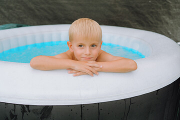 Young Boy Relaxing in Inflatable Pool with Calm Expression