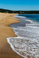 Seascape with beach, waves, sun and empty blue sky