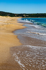 Seascape with beach, waves, sun and empty blue sky