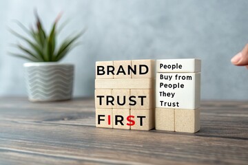 Wooden blocks displaying the message about trust and branding on a table with a plant
