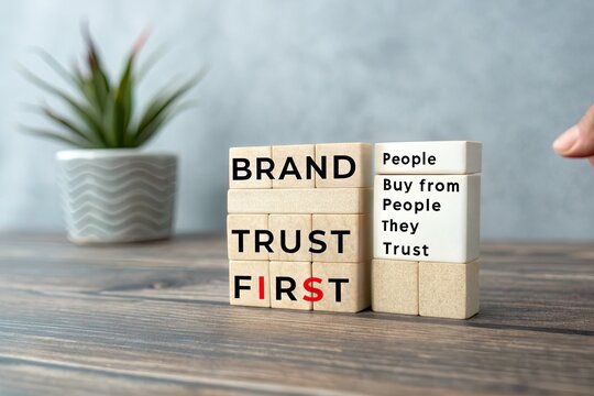 Wooden blocks displaying the message about trust and branding on a table with a plant
